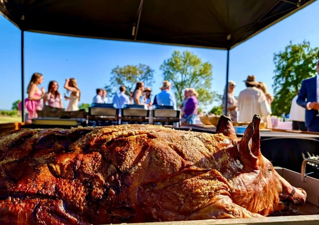 Hog roast catering setup at an outdoor event by Taste The Cracklin, serving guests nationwide.